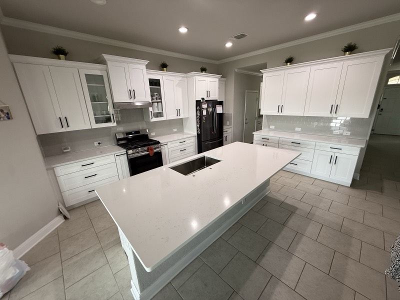 Bright white shaker kitchen with quartz island installed by Cabinet Bazaar in San Antonio