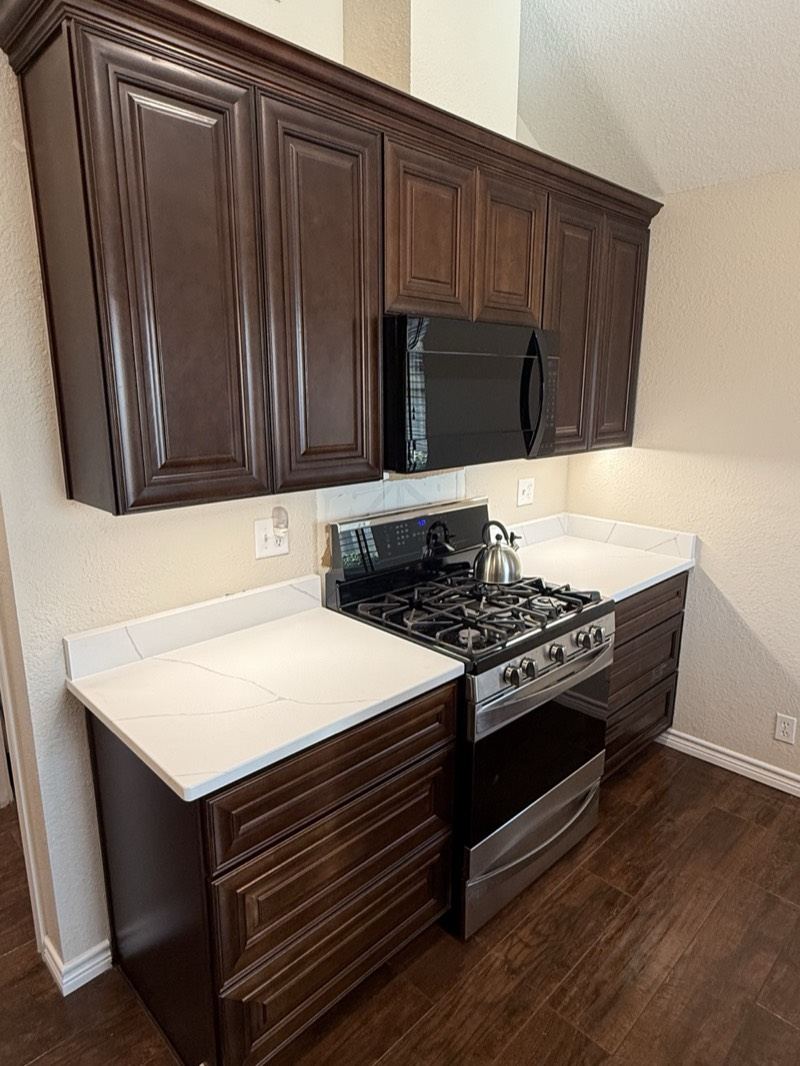 Espresso raised-panel kitchen cabinets with white quartz countertops
