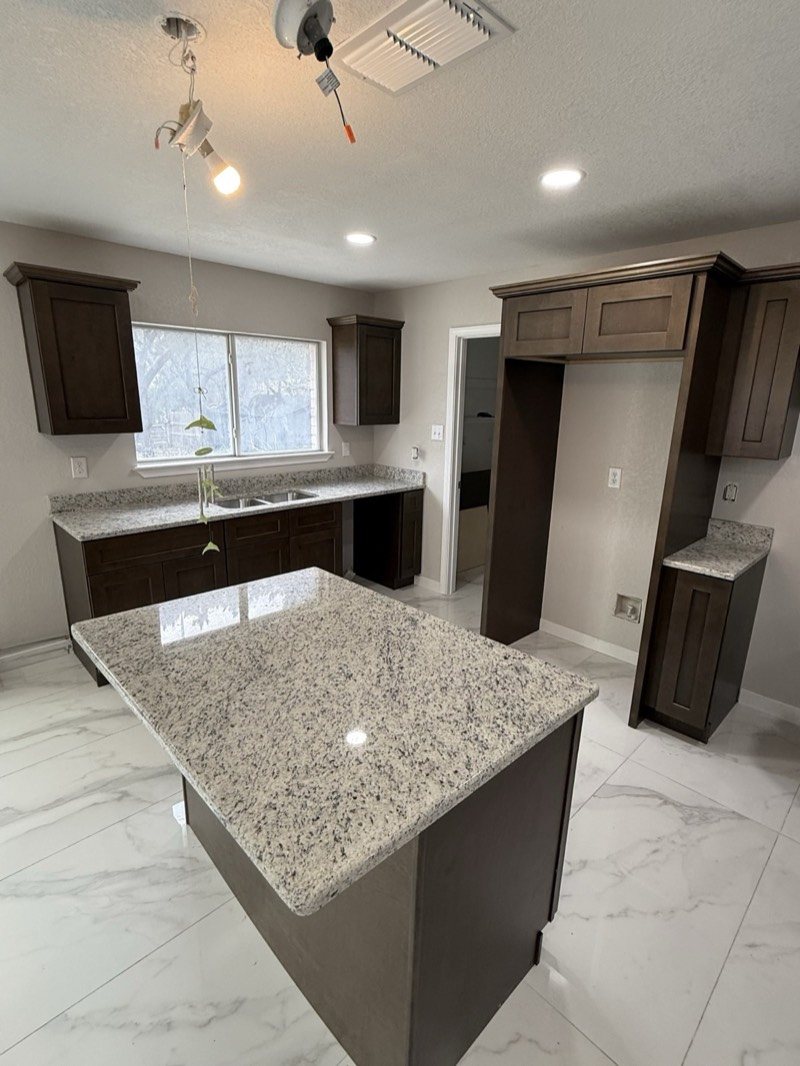 Espresso shaker kitchen cabinets with granite countertops and a window