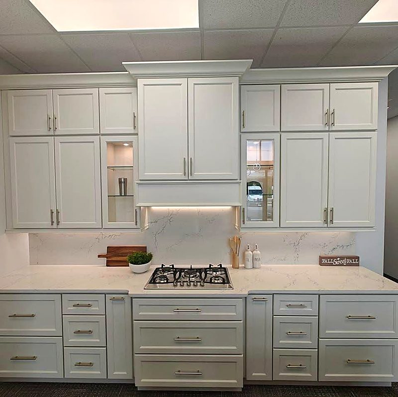Greige shaker kitchen cabinets with quartz countertops and a gas cooktop