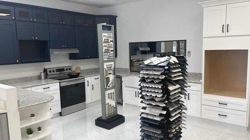 Inside the Cabinet Bazaar showroom in San Antonio with navy and white display kitchens and stone samples
