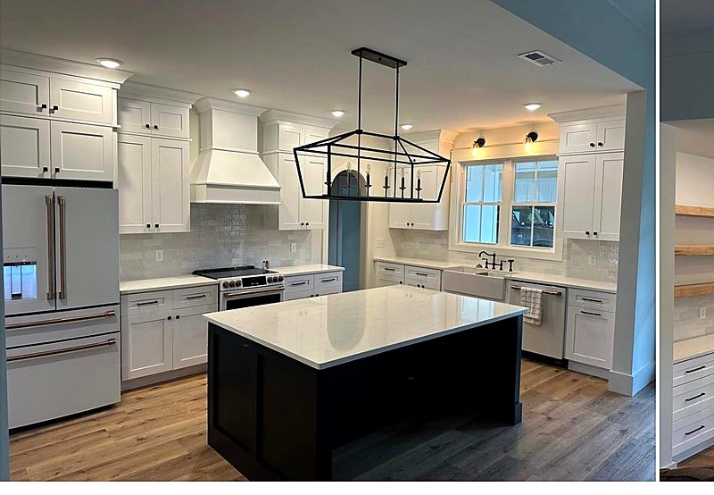 White kitchen with a dark island and a linear cage chandelier