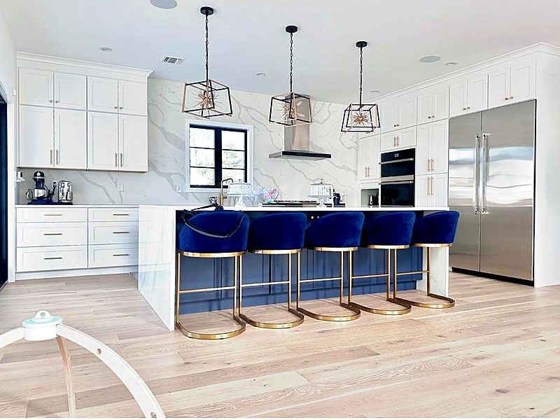 White kitchen with gold hardware and blue velvet bar stools