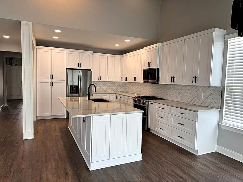 White kitchen with an island and a hexagon tile backsplash