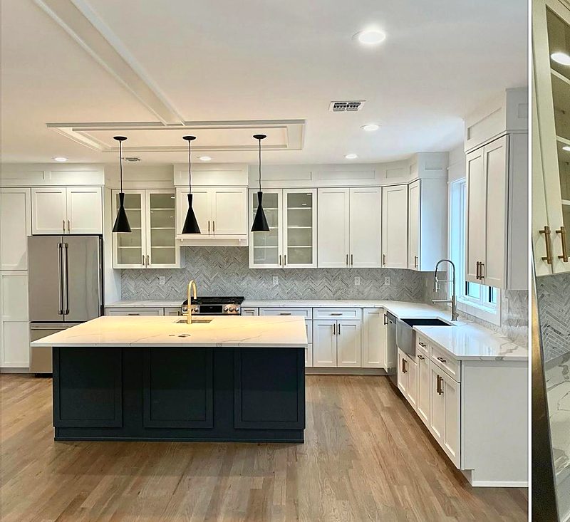 White and gray kitchen with a navy island and black pendant lights