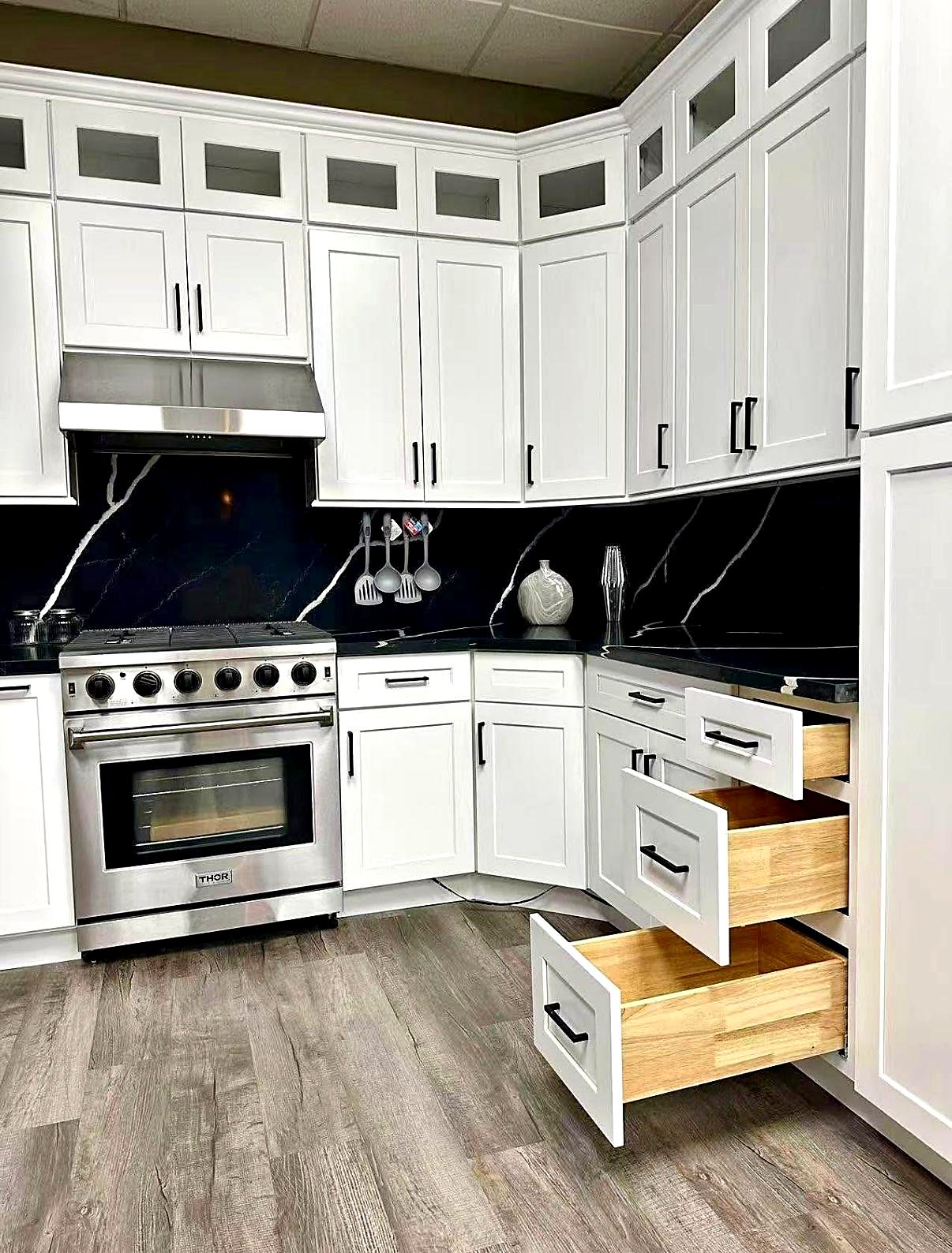 White kitchen cabinets with soft-close drawers beside a pro range