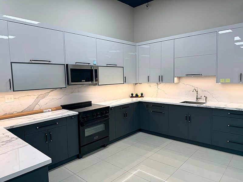 White upper and navy lower L-shaped kitchen with a marble backsplash
