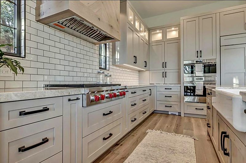 White shaker kitchen with subway tile backsplash and a professional gas range